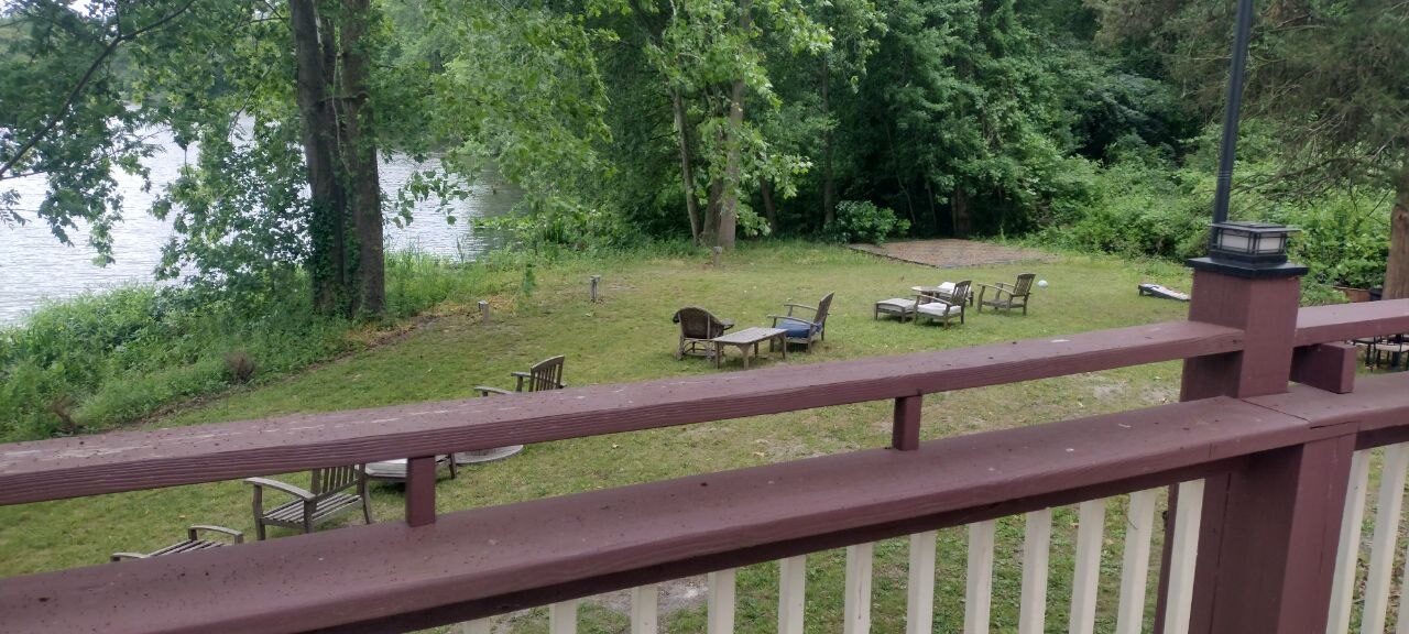 Pemberton Coffeehouse deck with a wrought-iron fire pit, scattered lounge chairs, and a red umbrella against the trees