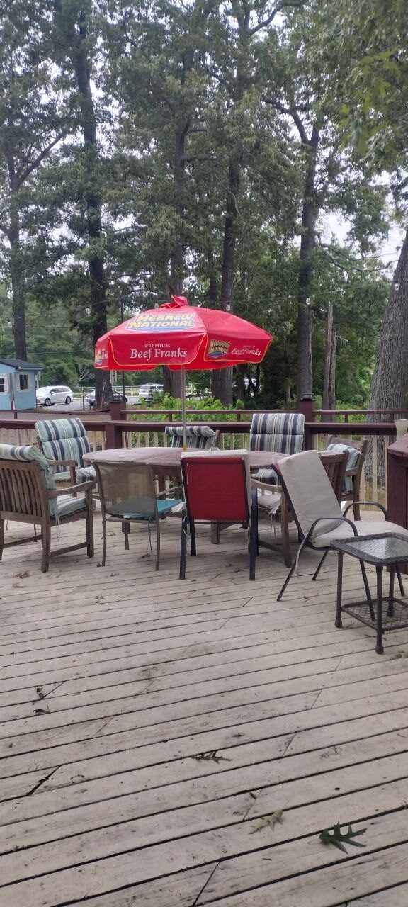 Pemberton Coffeehouse deck patio table under a red Hebrew National umbrella with cushioned chairs