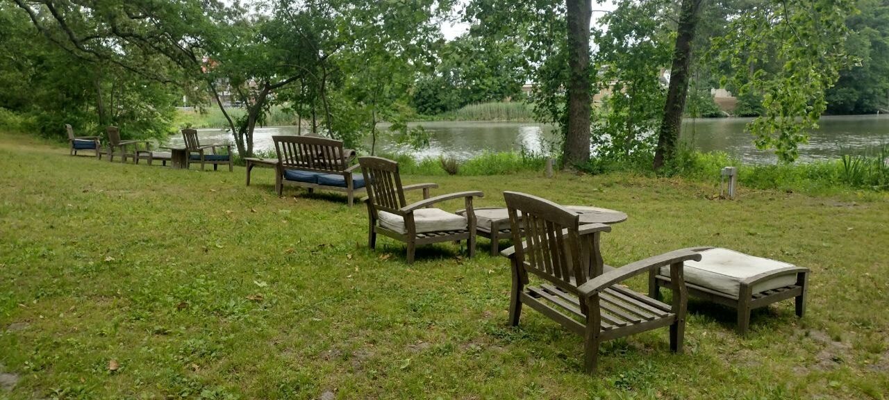 Adirondack chairs and benches along Pemberton's pond edge at lawn level